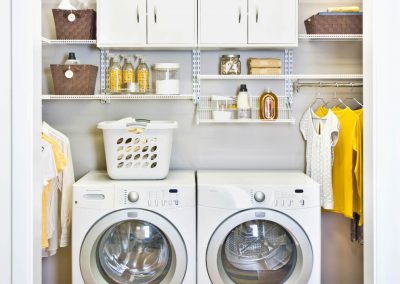Custom installed shelving for laundry room organization from Closet Solutions.